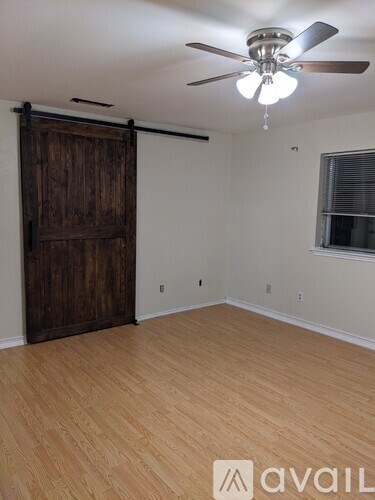 A room with a wooden floor and a sliding door.