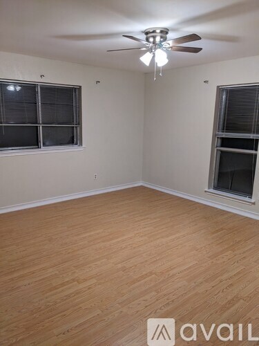 A room with wooden flooring and a ceiling fan.