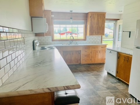 A kitchen with a marble countertop and wooden cabinets.