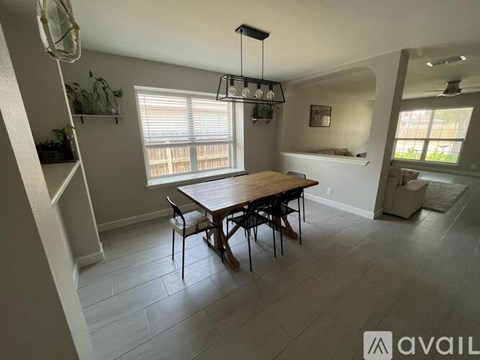 A dining room with a wooden table and chairs.