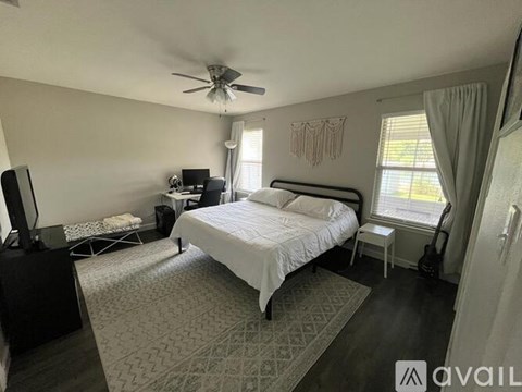 A bedroom with a bed, desk, and chair.
