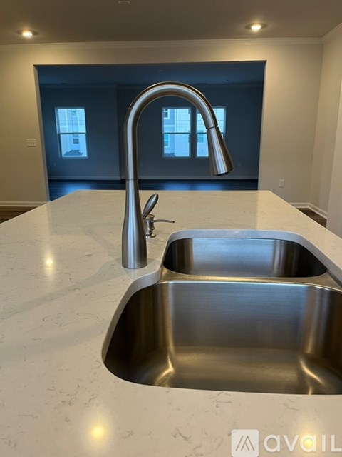 A modern kitchen with a stainless steel sink and faucet.