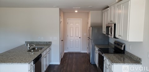 A kitchen with granite countertops and white cabinets.