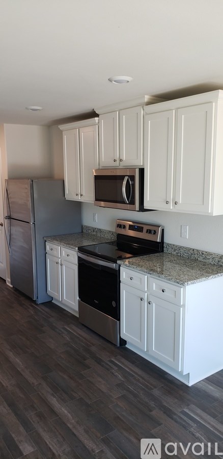 A kitchen with white cabinets and a granite countertop.
