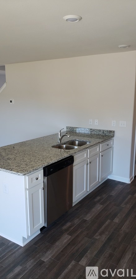 A kitchen with a granite countertop and white cabinets.