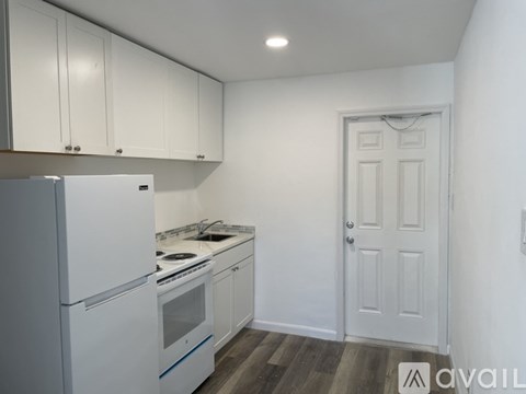 A kitchen with white appliances and cabinets.