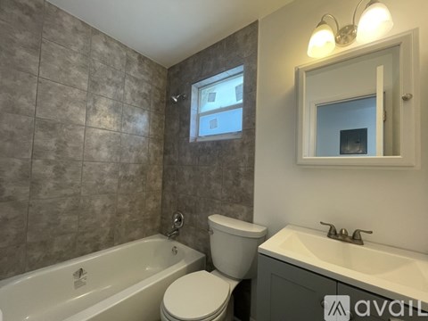 A bathroom with a tub, toilet, and sink.