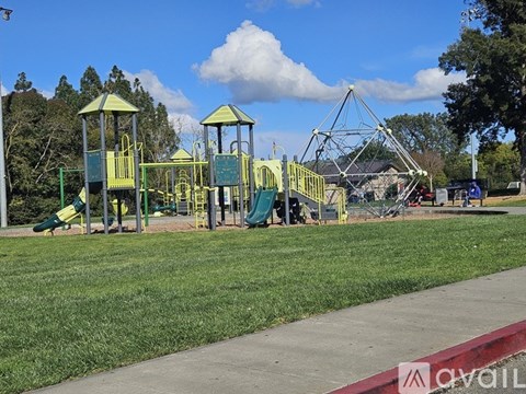 A playground with a green and yellow swing set.