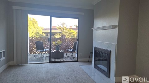 A living room with a fireplace and sliding glass doors leading to a patio.