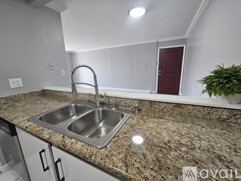 A kitchen with granite countertops and a double sink.