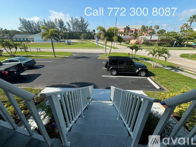 A view of a residential area with a car parked in the driveway and a house in the background.
