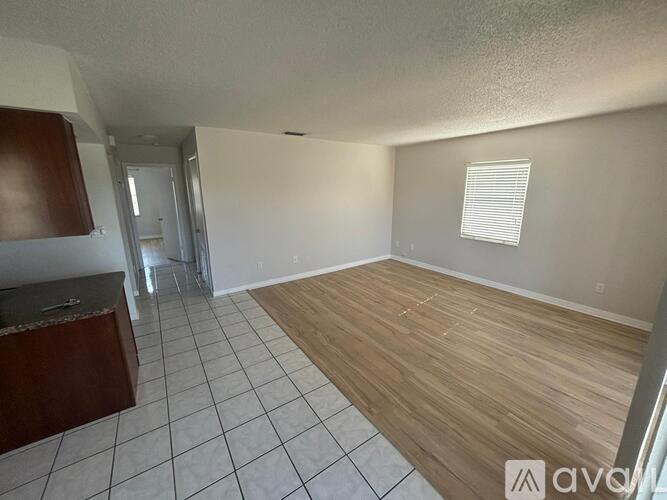 A room with wooden flooring and tiled walls.