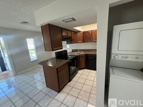 A kitchen with brown cabinets and a black stove top oven.