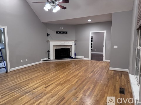A room with a fireplace and a ceiling fan.