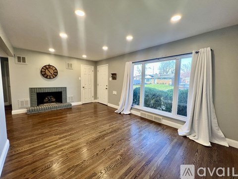 A living room with a fireplace and a large window.