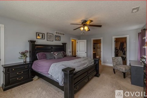 A bedroom with a bed, dresser, and chair.