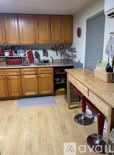 A kitchen with wooden cabinets and a countertop with a blue mat on the floor.