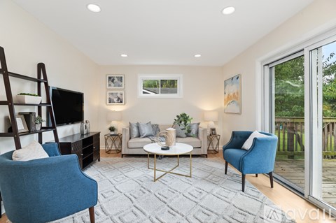 A living room with a blue chair and a white couch.