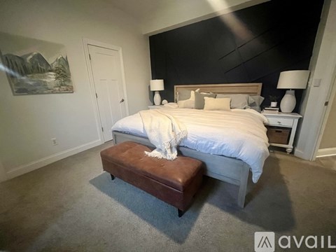 A bedroom with a large bed and a bench in front of it.