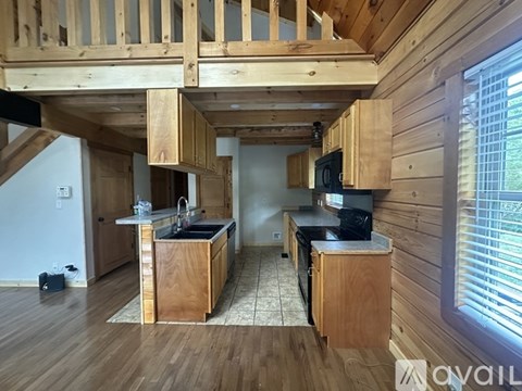 A kitchen with wooden cabinets and a countertop is available for rent.