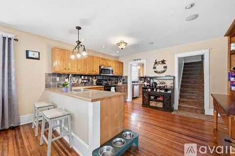 A kitchen with wooden cabinets and a white island with a sink.