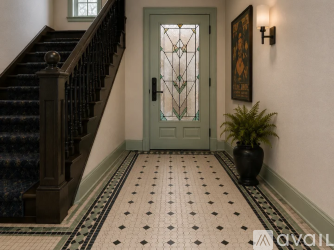 A staircase with a green door and a plant in a black vase.