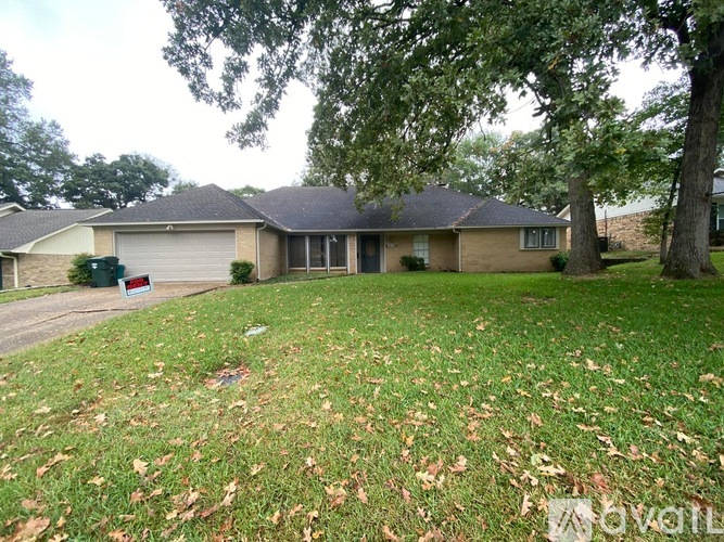 A house with a green lawn and trees in the background.