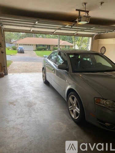 A silver car is parked in a garage.