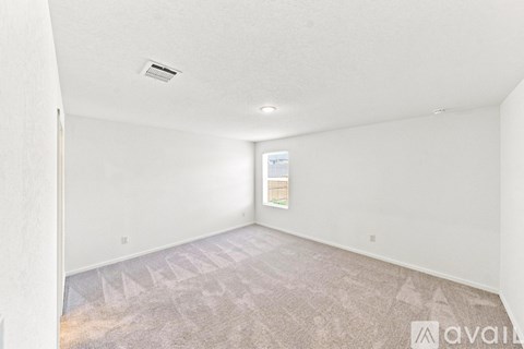 A room with a carpeted floor and a window showing a building outside.