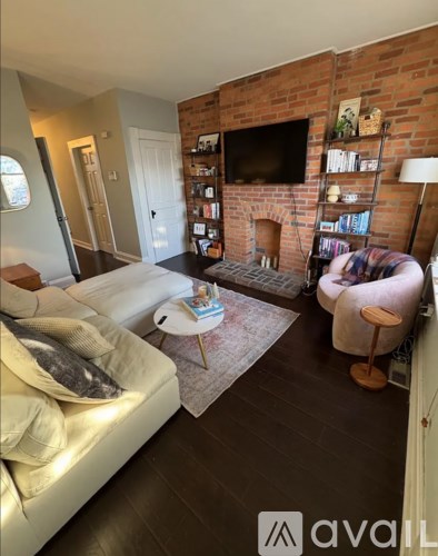 A living room with a white couch and a fireplace.