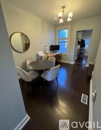 A dining room with a round table and chairs.