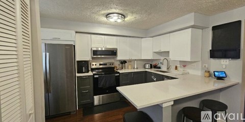 A kitchen with white cabinets and a refrigerator.