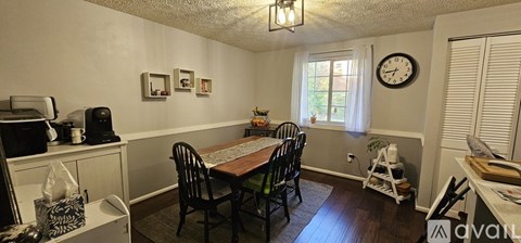 A dining room with a table and chairs.