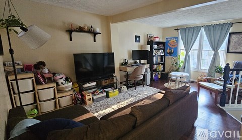 A living room with a television, a couch, and a bookshelf.