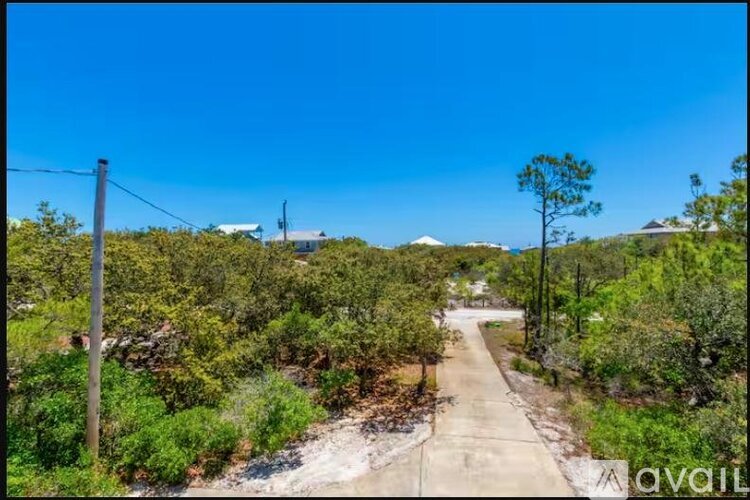 A pathway leads through a lush green landscape.
