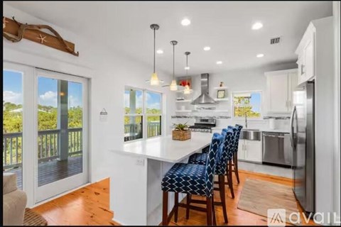 A kitchen with a table and chairs with a view of the outside.
