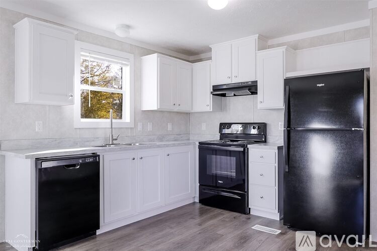 A kitchen with black appliances and white cabinets.