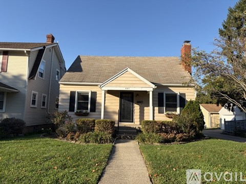 A house with a brown roof and a grey front yard.