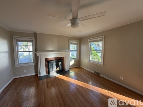 A room with a fireplace and a ceiling fan.