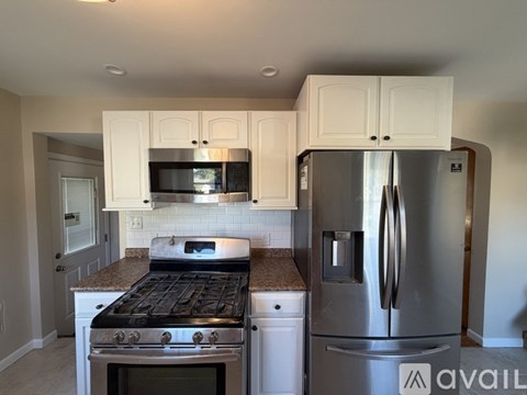 A kitchen with a stove, microwave, and refrigerator.