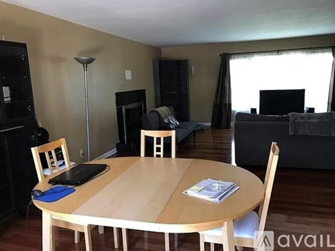 A dining room with a wooden table and chairs.