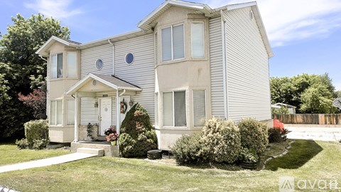 A two-story house with a front porch and a small garden.