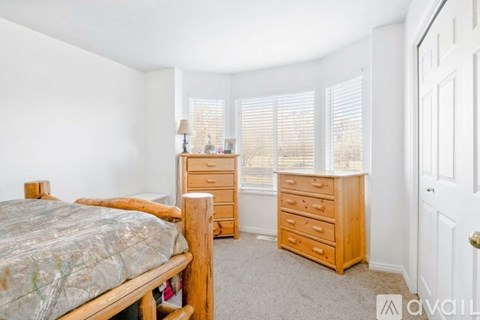 A bedroom with a bed, dresser, and nightstand.