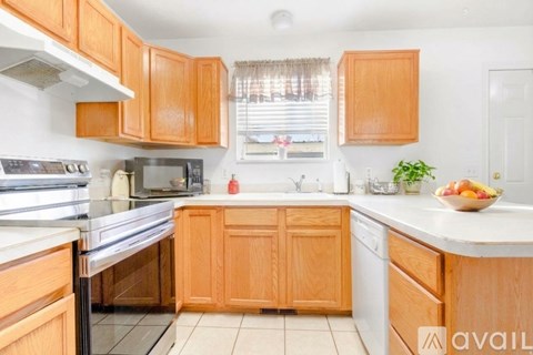 A kitchen with wooden cabinets and a white countertop.