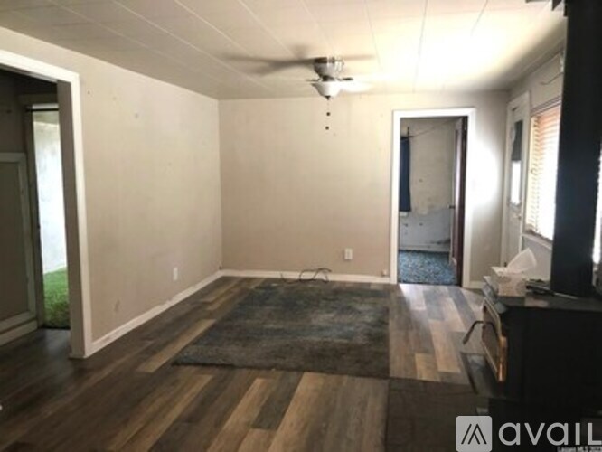 A room with a rug on the floor and a ceiling fan.