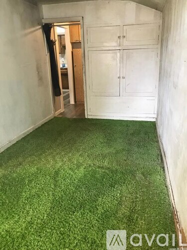 A room with artificial grass carpeting and white walls.