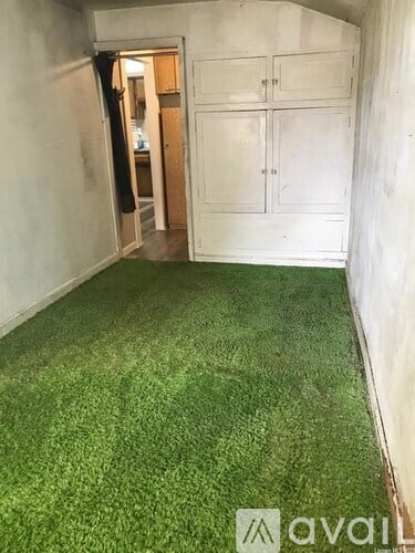 A room with artificial grass carpeting and white walls.