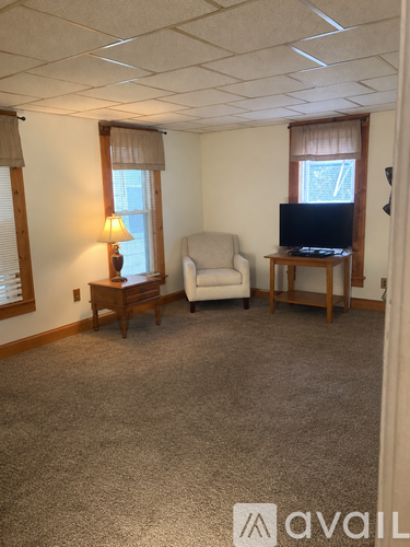 A living room with a couch, chair, and television.