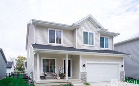 A two-story house with a garage and a covered porch.