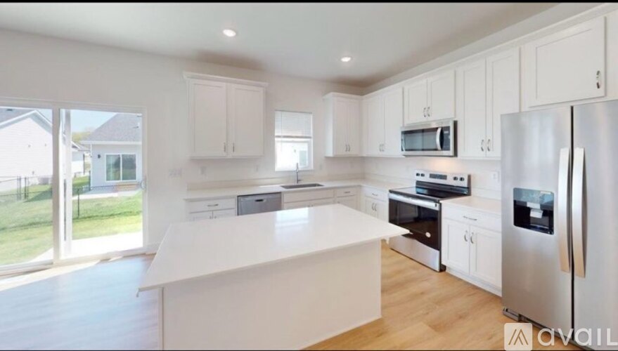 A modern kitchen with white cabinets and stainless steel appliances.